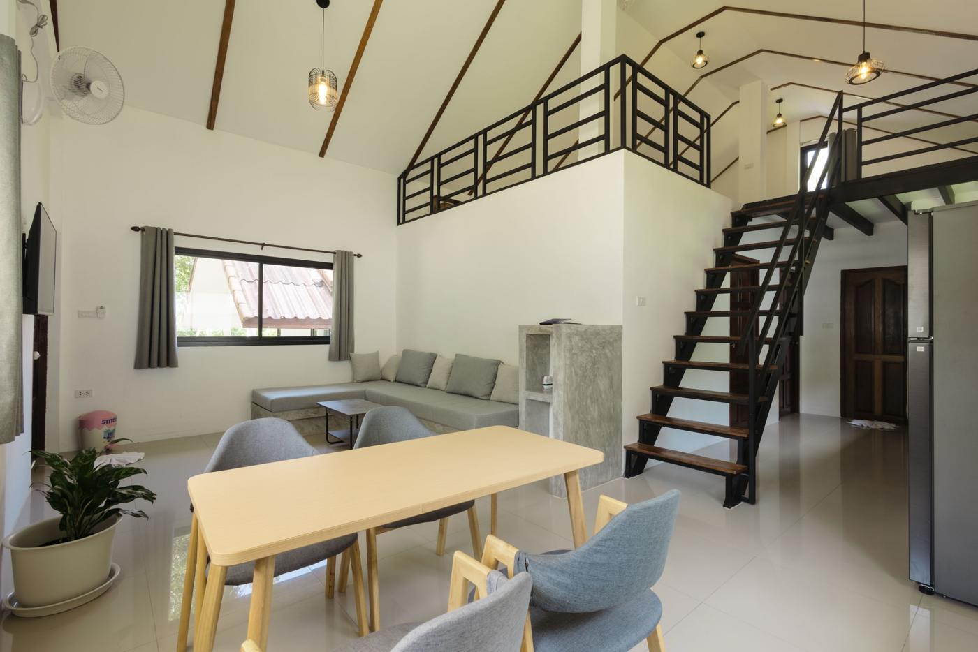 Open living and dining room under a high beamed ceiling