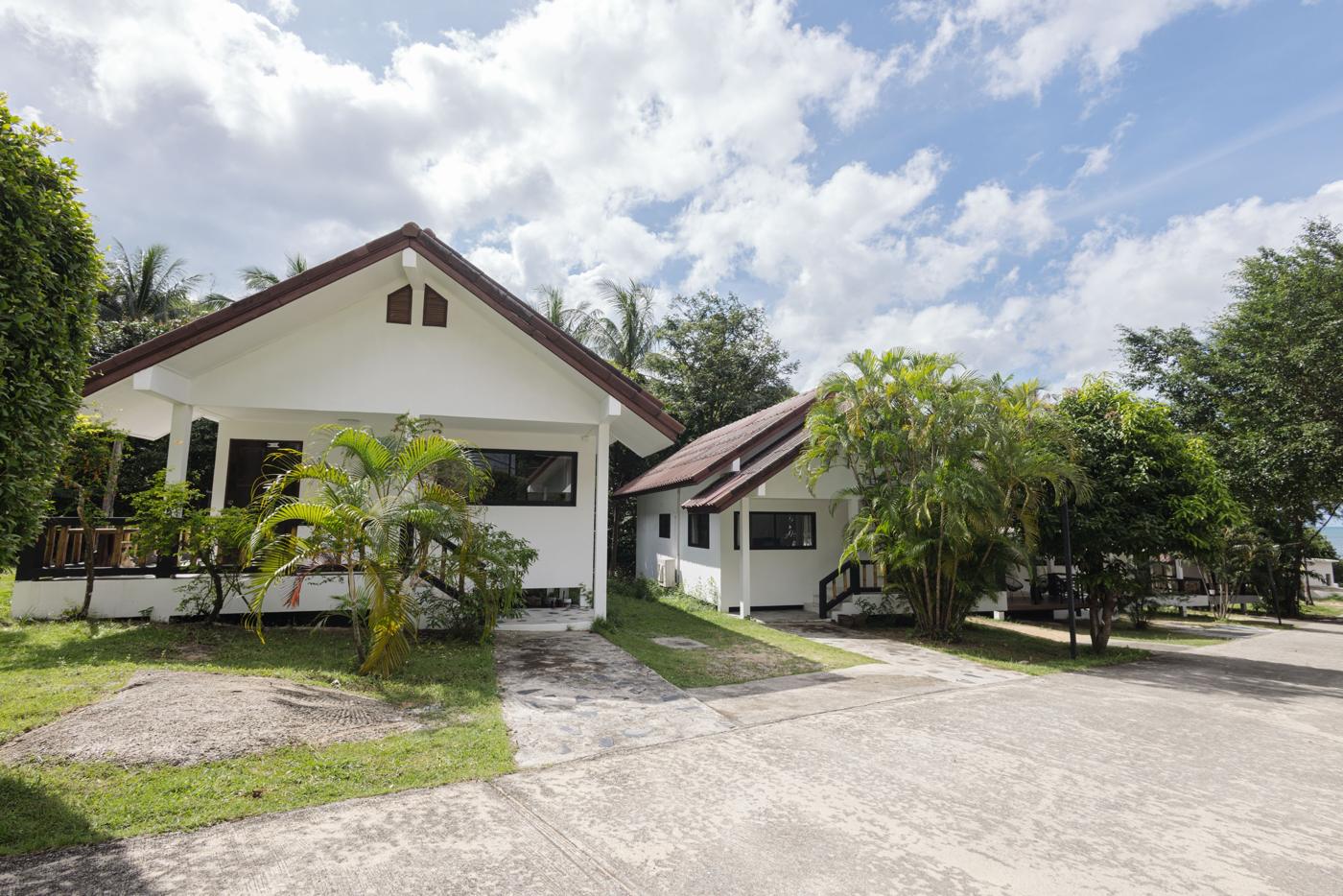 White bungalows along the path between palm trees