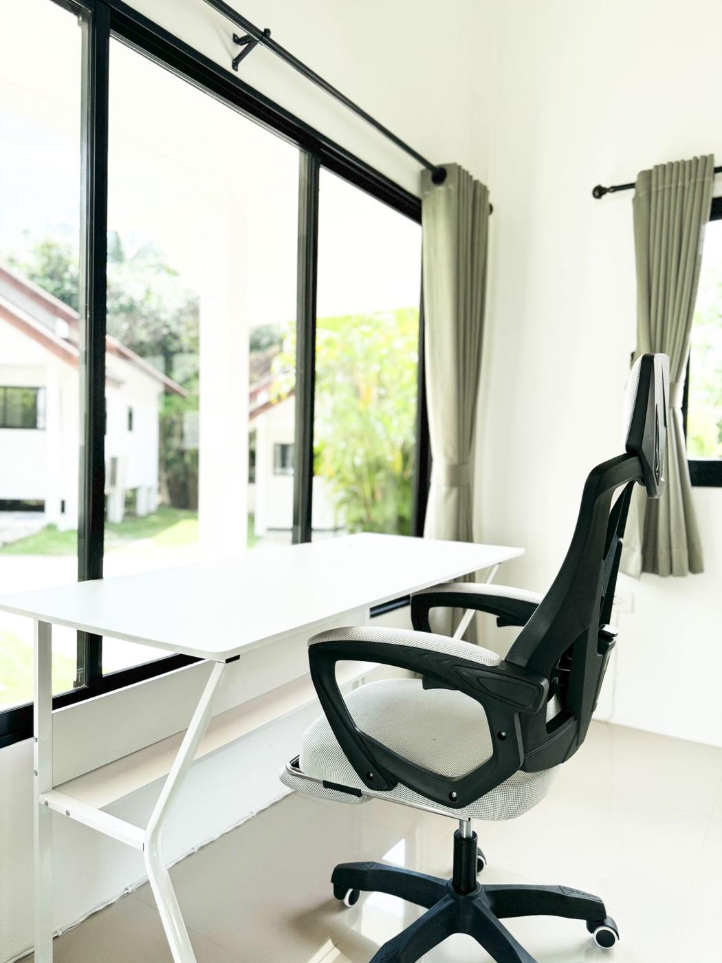 Work desk and chair by a large window
