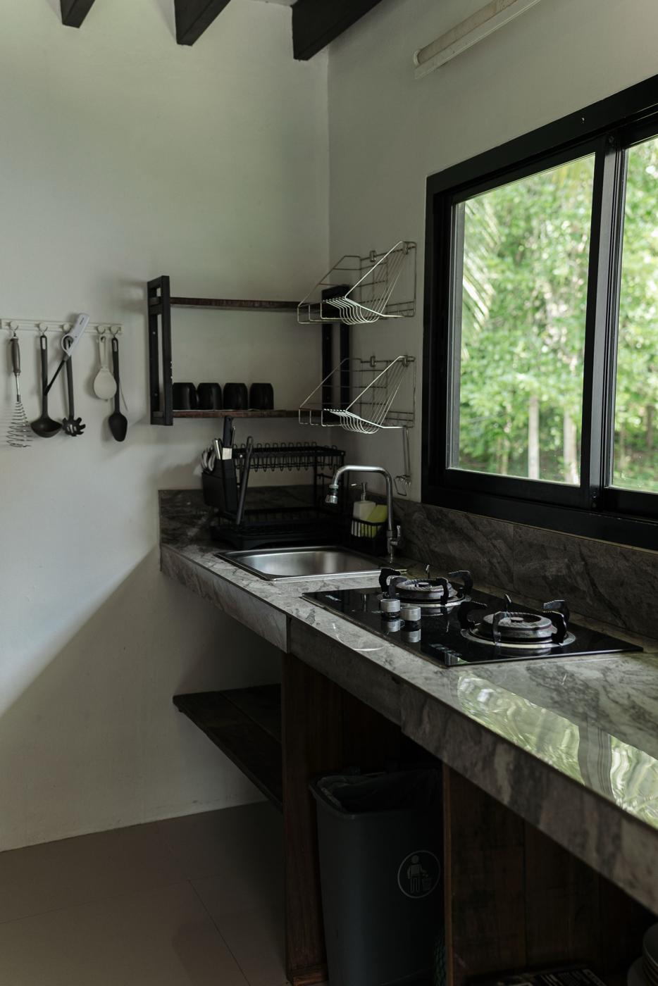 Kitchen with sink, two-burner stove and a window onto the trees